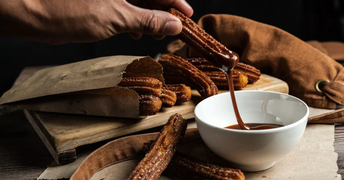churros dipped in a bowl of chocolate