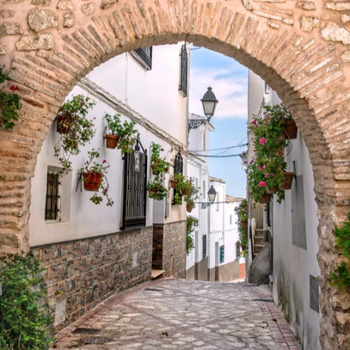 castril spain arched cobblestone street leading to the beach in the distance