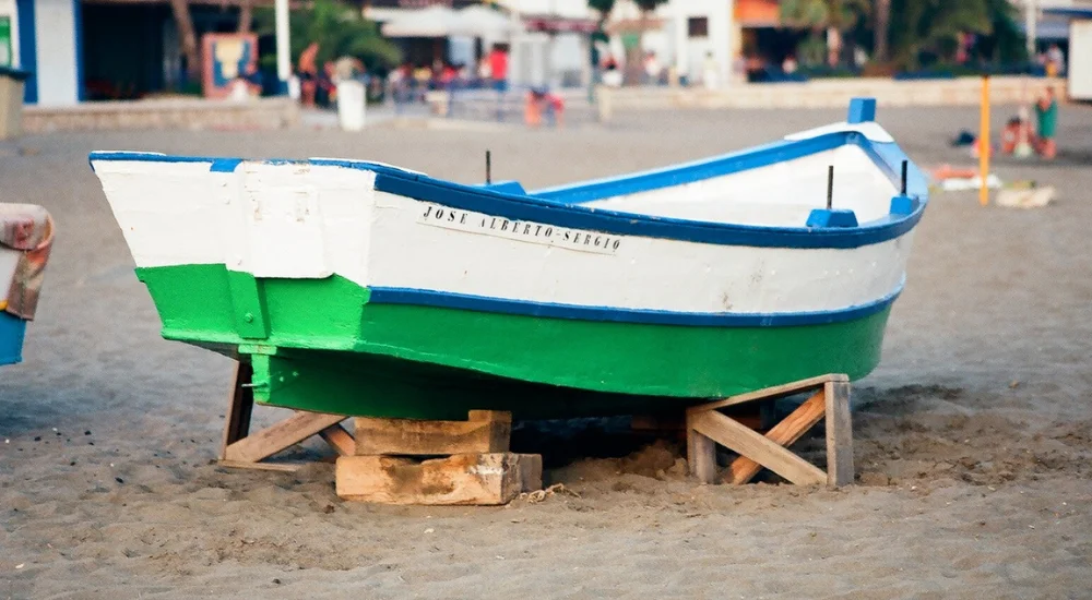 small fishing boat painted in blue, white and green