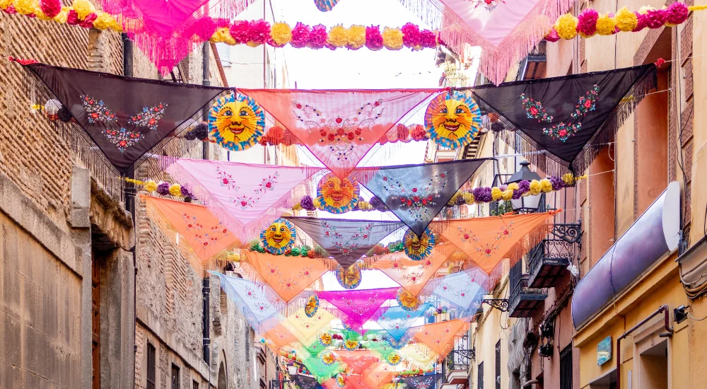 fiesta decorations hanging across a street in spain 