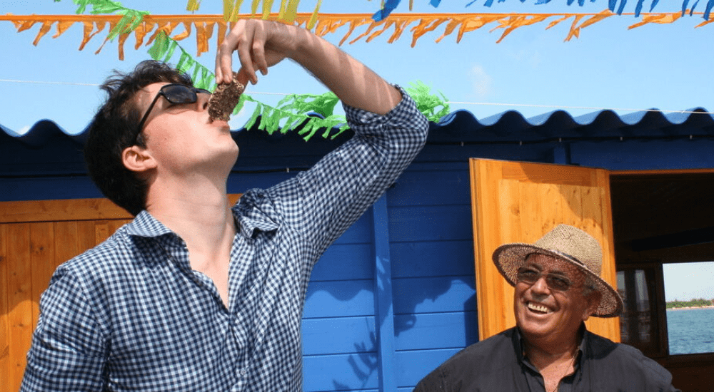 local tour guides in spain with tour attendee enjoying fresh oysters