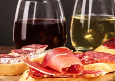 cured meat taps with 2 glasses of wine sitting on a table